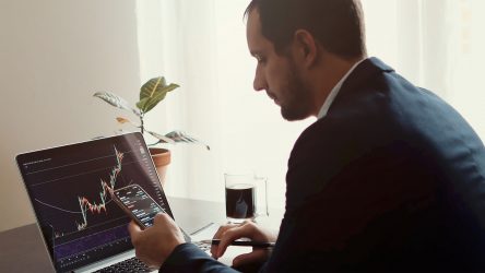 investment stockbroker stock market analysis. Stock trader making risk analysis graph on phone screen. Trader using multiple devices for stock price prediction.